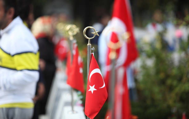 Turkish flag in Turkish martyrdom graveyard, there are people in the backplane. Turkish flag in Turkish martyrdom graveyard, there are people in the backplane. martyr stock pictures, royalty-free photos & images