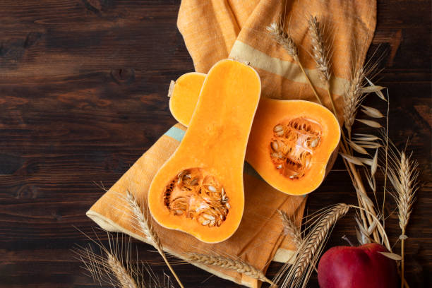 istock Pumpkin, red apple, wheat on wooden table 1330598616
