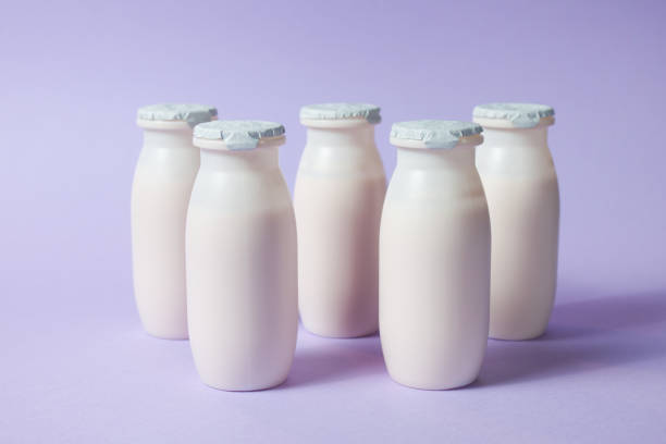 istock Bottles with probiotics and prebiotics dairy drink on light purple background. 1330601435