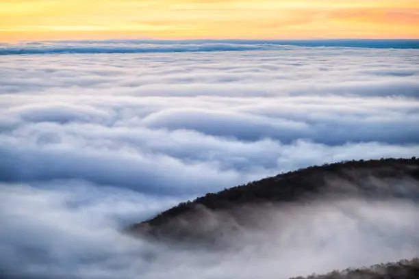 Clouds mist fog covering mountain peak in Wintergreen resort town in Blue Ridge mountains in autumn fall high angle aerial above view of inversion cloud