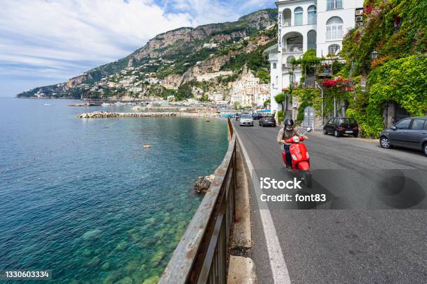 A Red Vespa Driving On The Beautiful Coastal Road Overlooking The Mediterranean Sea Amalfi Italy - Fotografias de stock e mais imagens de Vespa - Nome de Marca de Lambreta