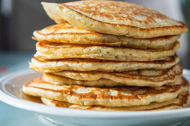 Macro closeup side view of stack of buttermilk pancakes on plate as traditional breakfast brunch dessert Macro closeup side view of stack of buttermilk pancakes on plate as traditional breakfast brunch dessert thick photos stock pictures, royalty-free photos & images