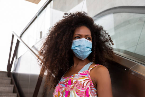 istock young black woman with mask on stairs at subway train exit 1330605021