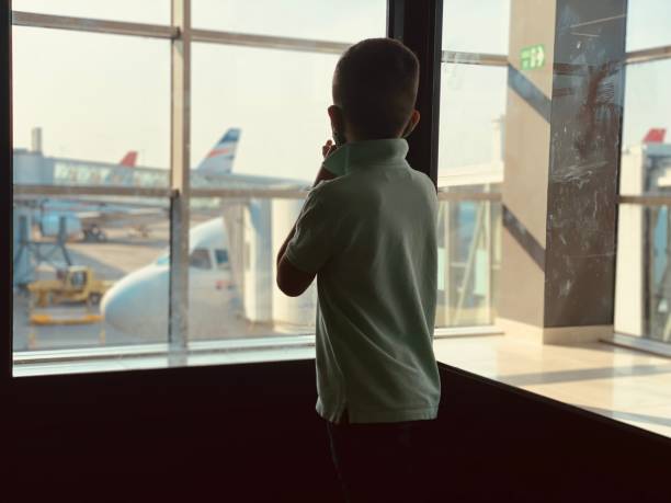 istock Boy is standing near window on the airport. 1330608315
