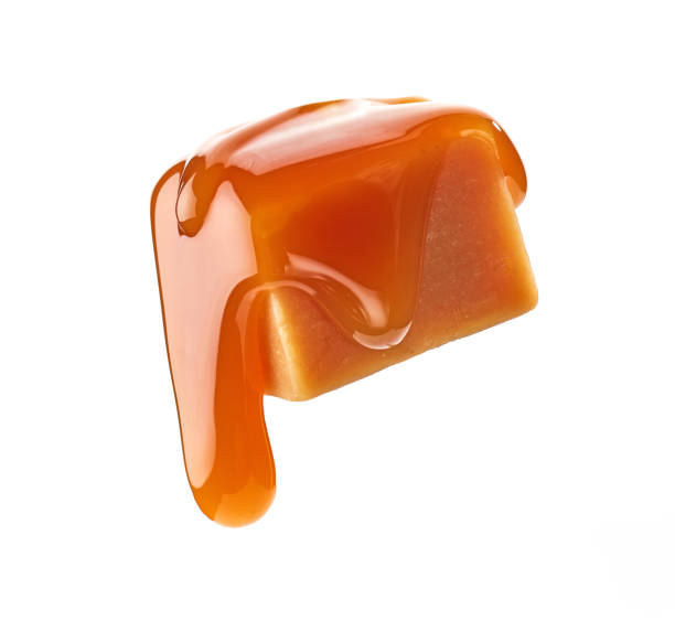 istock caramel sauce flowing on flying caramel candy 1330612440