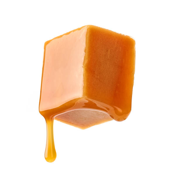 istock caramel sauce flowing on flying caramel candy 1330612444