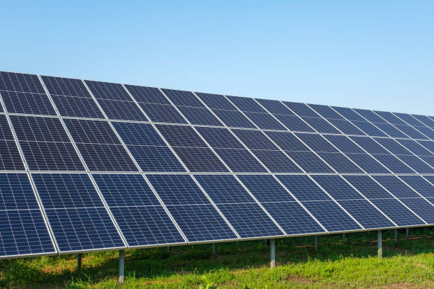 istock Row of solar panels on a solar farm under a blue sky. 1330613107