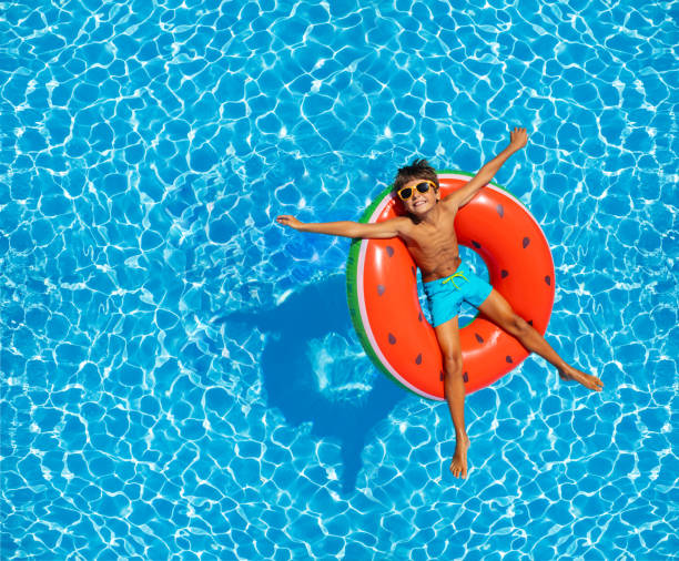 istock Boy swim in pool on inflatable ring from above 1330615937