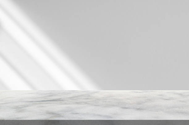 istock Marble table with window shadow drop on white wall background for mockup product display 1330617227