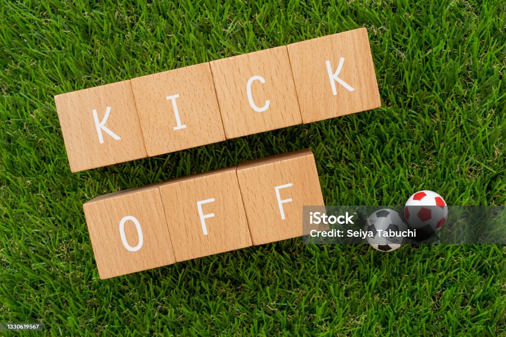 KICK OFF; Wooden blocks with "KICK OFF" text of concept and soccer ball toys. Beginnings Stock Photo