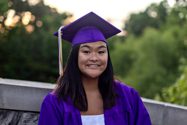 Asian young woman smiles in her cap and gown - fotografia de stock