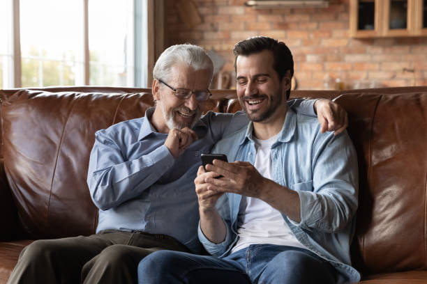 istock Happy senior 70s father and grown son using smartphone together 1330622442