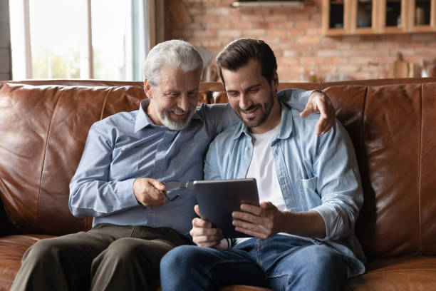 istock Happy grown son teaching senior father to use tablet 1330622444