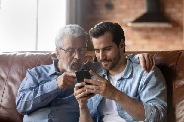 istock Grown son teaching elderly 70s dad to use mobile app 1330622448