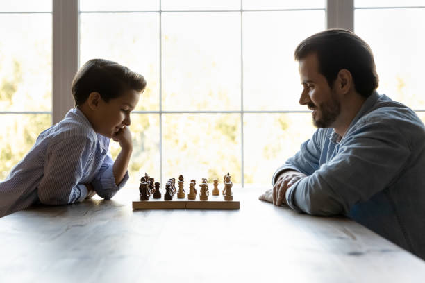 istock Focused thoughtful clever son and dad playing chess 1330622458