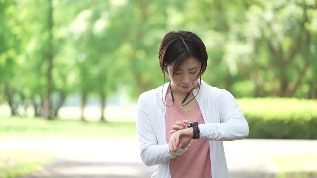 A woman jogging while listening to music on her smartphone