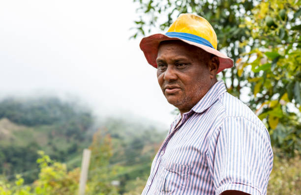 Senior afro american farmer standing in countryside. Real people