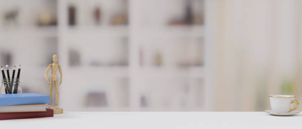 istock Copy space on white table with figure, colourful books, pencils, coffee cup and blurred background 1330631675