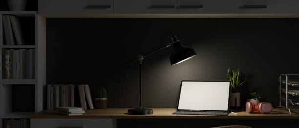 istock Work space at night with open laptop and light from table lamp, late night working 1330632179