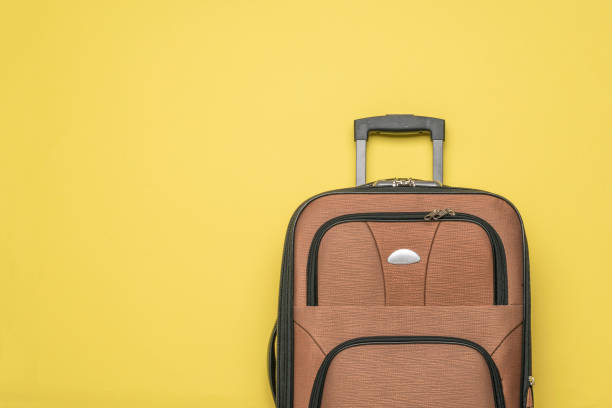 istock A convenient travel suitcase on a yellow background. Flat lay. 1330632889