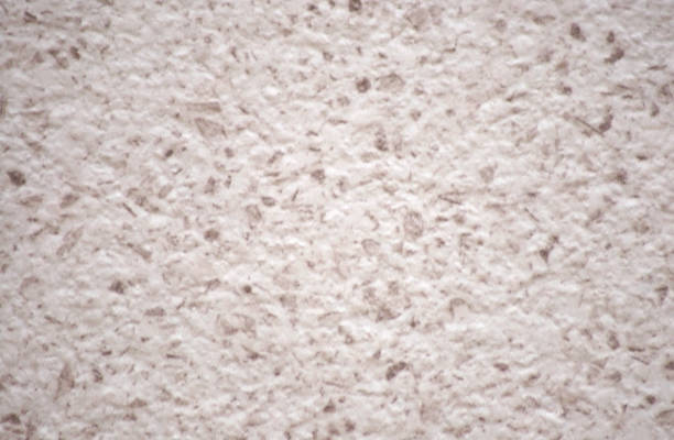 istock Roughly finished surface of pink stone with small red blotches. 1330634338