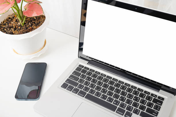 istock mock up laptop computer blank white screen, eyeglasses and smartphone white table 1330634508