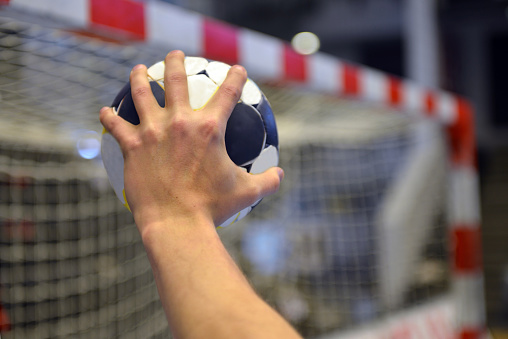 Closeup of a handballplayer about to throw the handball into the goal.