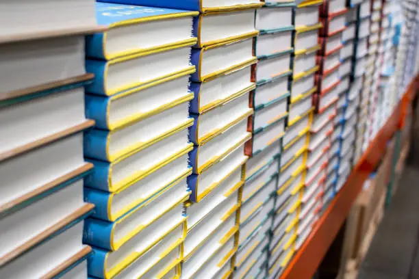 A view of stacks of hardback covered books for sale at a bookstore.