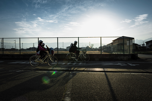 OSAKA, JAPAN - MAR 2015 : Young Japanese schoolgirl riding bicycles to practice on street in the morning. Activity of young schoolgirl in holiday or free time.