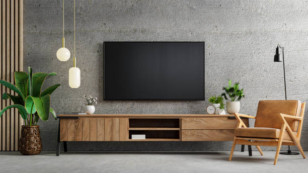 el interior de la sala de estar tiene gabinete de tv y sillón de cuero en habitación de cemento con pared de concreto. - canal fotografías e imágenes de stock