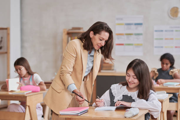 istock Teacher Helping Kids in School 1330638997