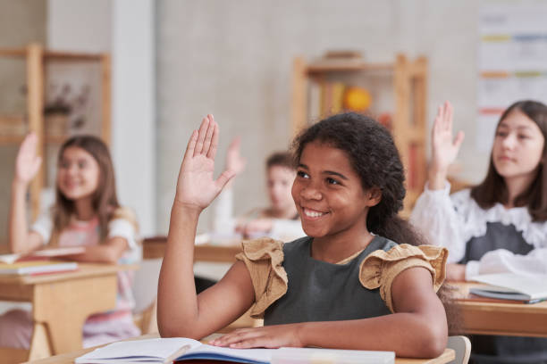 istock Girl Raising Hand in School 1330639550
