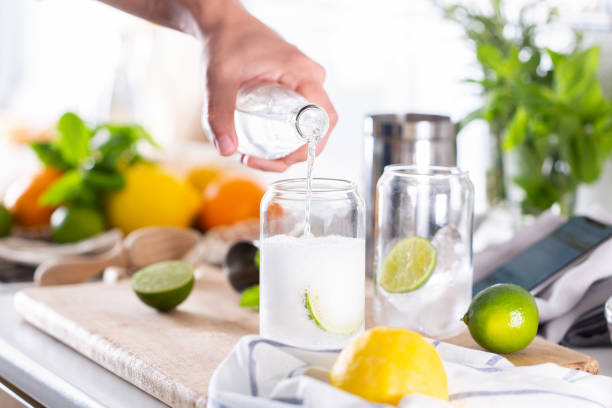 mixólogo haciendo cóctel refrescante con hard seltzer en casa - instructor one person fruit drinking fotografías e imágenes de stock