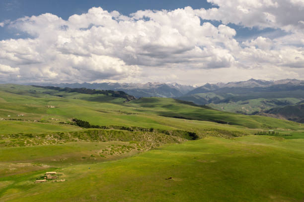 istock Mountain peaks and grassland are under white clouds. 1330641007