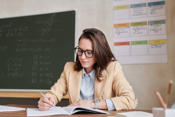 istock Female Teacher at Desk in School 1330641889