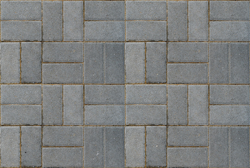 Seamless texture of a pedestrian path paved with artificial grey stone.