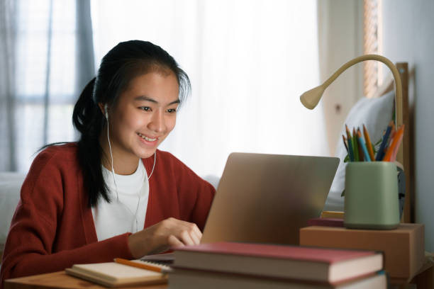 istock asian woman using laptop with headphone 1330643555