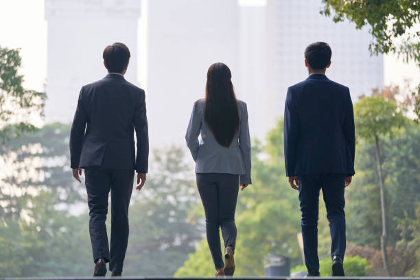istock asian corporate executives walking on street in downtown 1330645596