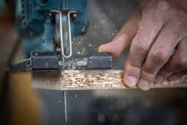istock Close-up process of cutting wood board with jigsaw. 1330645936