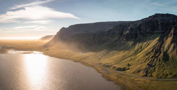 Sudurland Iceland South Coast Sunset Panorama. Stiched aerial drone point of view panorama along the south coast mountain range and north atlantic ocean of Sudurland in South Central Iceland. Country Road Route 1 along coastal glacier mountain range between Selfoss and Vik, South Central Iceland, Iceland, Nordic Countries, Europe