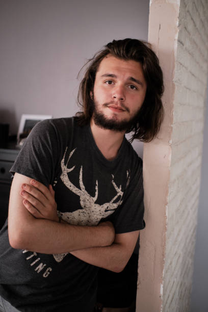 istock Young guy poses at the camera as he stands by the wall. 1330648272