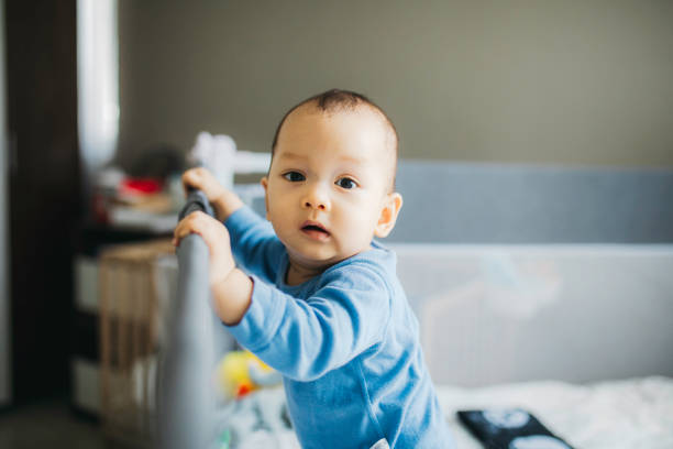 istock portrait asian baby standing and hold a bed frame 1330653029