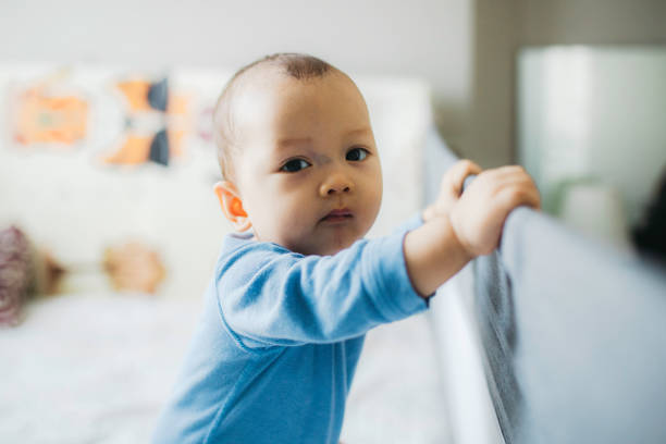istock portrait asian baby standing and hold a bed frame 1330653053