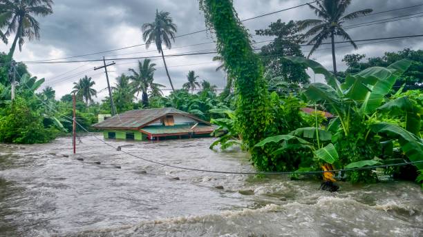 A rural home being submerged by floodwaters caused by torrential rain in the Philippines. Rising water levels submerging a house as heavy monsoon rains cause major floods in Baco, Oriental Mindoro, Philippines on July 23, 2021. monsoon stock pictures, royalty-free photos & images