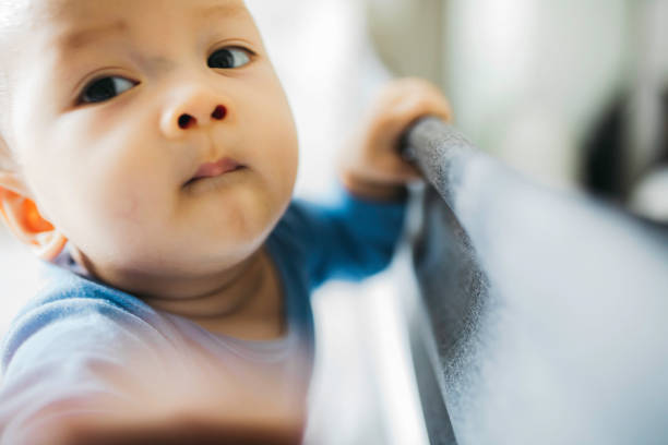 istock portrait asian baby standing and hold a bed frame 1330653090