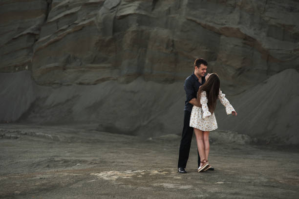 istock Happy couple dancing outdoors at summertime on gray sand background 1330654498