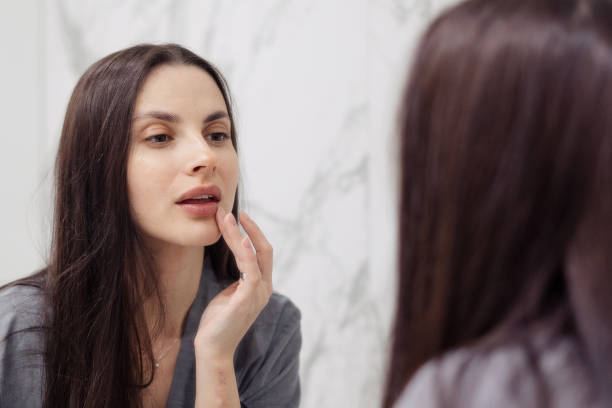 istock Attractive woman applying scrub on lips in bathroom 1330655869
