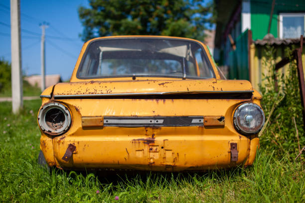 Old yellow wrecked car in vintage style. Abandoned rusty yellow car. Old yellow wrecked car in vintage style. Abandoned rusty yellow car. Close-up of the headlights of the front view of a rusty, broken, abandoned car near the house. Concept of abandoned used car. distressed rusty vintage pickup truck close up detail stock pictures, royalty-free photos & images