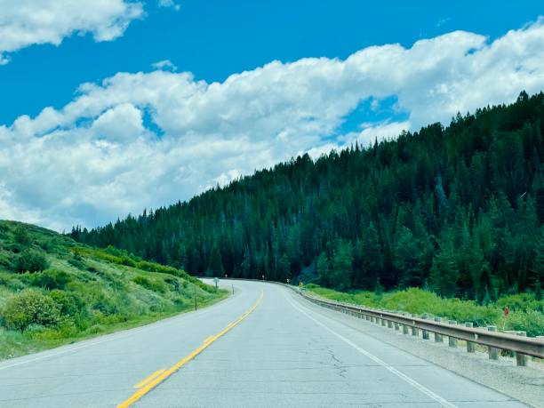 istock Open two-lane highway through lush forest landscape 1330661127