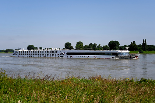 Duesseldorf, Germany, July 23, 2021 - Rhine cruise ship A ROSA-FLORA in the background the Duesseldorf airport bridge in Stockum